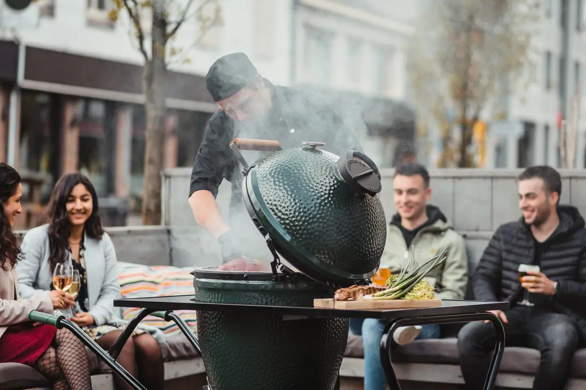 De kok grilt op het terras terwijl gasten genieten